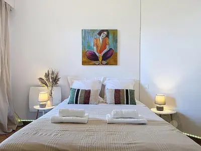 a bedroom with a large bed with two lamps at Villa Mimosa 150 m from Pinarello Beach in Zonza