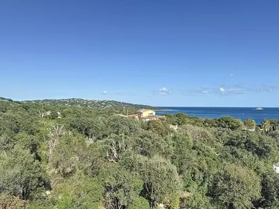 a house sitting on top of a hill next to the ocean at Villa Mimosa 150 m from Pinarello Beach in Zonza