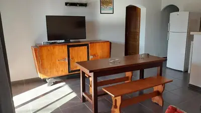 a living room with a table and a television on a cabinet at Casapiana 07 in Porto-Vecchio
