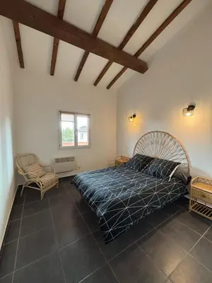 a bedroom with a large bed and a chair at Casapiana 07 in Porto-Vecchio