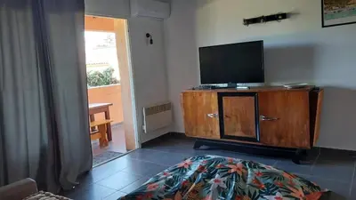 a living room with a flat screen tv on a wooden cabinet at Casapiana 07 in Porto-Vecchio