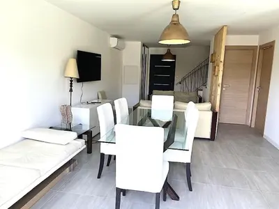 a dining room with a glass table and white chairs at Villa Favone 3 in Favone
