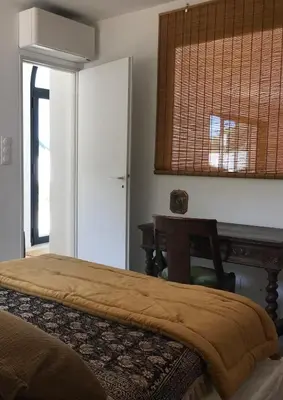 a bedroom with a bed and a table and a window at Casa di a felicita in Bonifacio