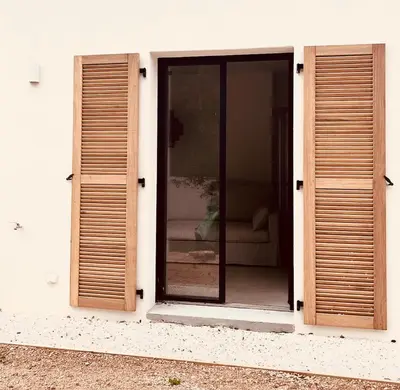 an open window of a white building with wooden shutters at Casa di a felicita in Bonifacio