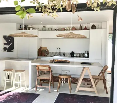 a kitchen with a white counter and stools at Casa di a felicita in Bonifacio