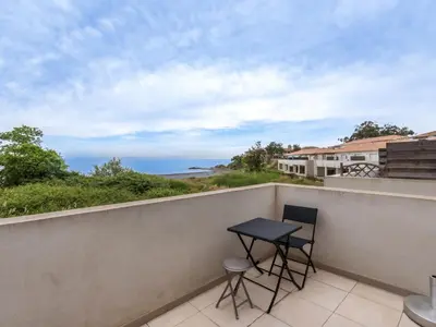 a balcony with a table and two stools at Studio Brigitte by Interhome in Linguizzetta