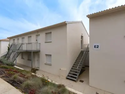 a white building with a staircase next to it at Studio Brigitte by Interhome in Linguizzetta