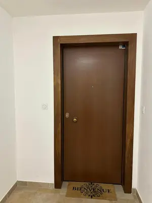 a brown door in a room with a rug at Appart, résidentiel penta-di-Casinca in Penta-di-Casinca