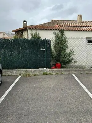a fence in front of a house with a garage at Appart, résidentiel penta-di-Casinca in Penta-di-Casinca