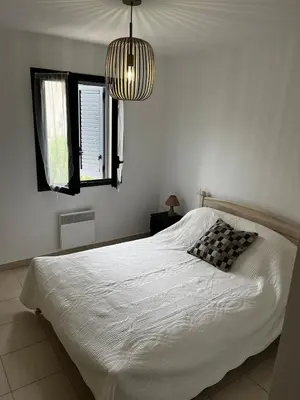 a bedroom with a white bed and a window at Appart, résidentiel penta-di-Casinca in Penta-di-Casinca