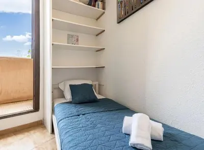 a small bed in a room with a window at Appartamentu Soli di Sud - St Cyprien in Lecci