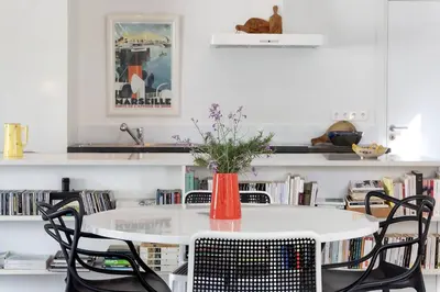 a white table with chairs and a vase with flowers at Belle villa 3 chambres au cœur du maquis in Porto-Vecchio