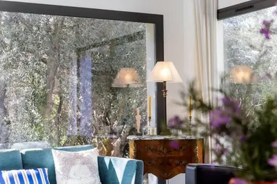 a living room with a couch and a large window at Belle villa 3 chambres au cœur du maquis in Porto-Vecchio