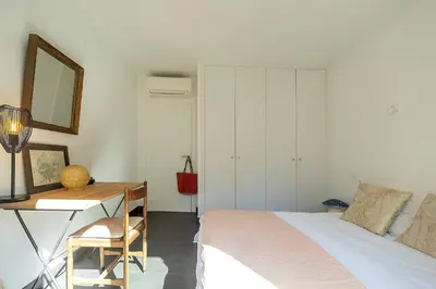 a bedroom with a bed and a desk with a mirror at Belle villa 3 chambres au cœur du maquis in Porto-Vecchio