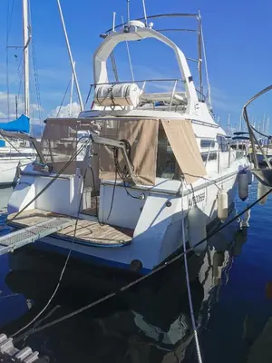 a white boat is docked in the water at appartement flottant in Ajaccio