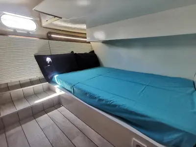 a small room with a blue bed on a boat at appartement flottant in Ajaccio