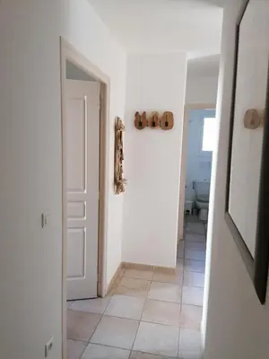 a hallway with a white door and a tile floor at villa dans petite résidence avec piscine à 10 minutes des plages proche PORTO VECCHIO in Porto-Vecchio