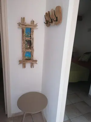 a room with a table and a cross on the wall at villa dans petite résidence avec piscine à 10 minutes des plages proche PORTO VECCHIO in Porto-Vecchio