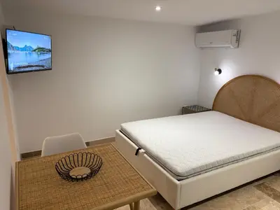 a bedroom with a bed and a table with a tv on the wall at Appartement 2 personnes les pieds dans l'eau in Vico