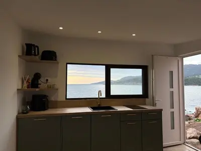 a kitchen with a sink and a window with a view at Appartement 2 personnes les pieds dans l'eau in Vico