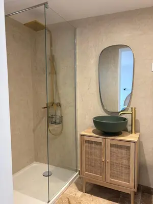 a bathroom with a shower with a sink and a mirror at Appartement 2 personnes les pieds dans l'eau in Vico
