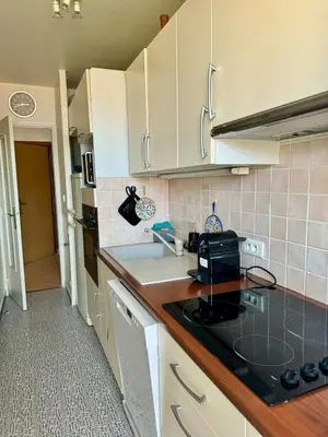 a kitchen with white cabinets and a black counter top at Studio cosy au cœur de Propriano in Propriano