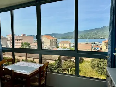 a room with a table and a view of the water at Studio cosy au cœur de Propriano in Propriano