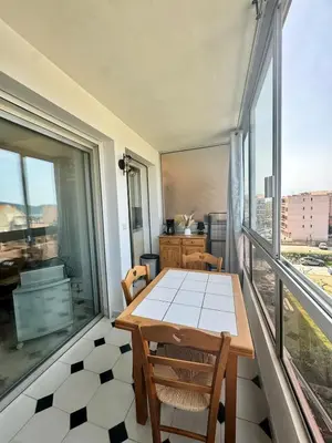 a table and chairs in a room with a large window at Studio cosy au cœur de Propriano in Propriano
