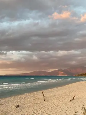 a beach with a cloudy sky and the ocean at Casa San Stefanu in Olmeta-di-Tuda
