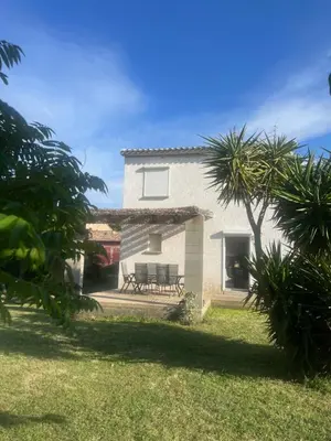 a white house with a bench in the yard at Casa San Stefanu in Olmeta-di-Tuda