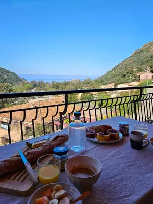 a table with plates of food on it with a view at T2 vue mer & montagne Golfe de Porto-Ota in Porto Ota