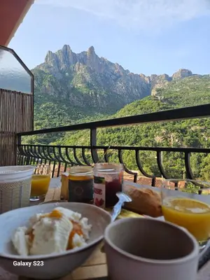 a table on a balcony with a view at T2 vue mer & montagne Golfe de Porto-Ota in Porto Ota