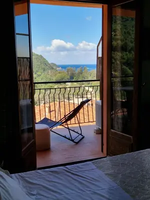 a bedroom with a view of the ocean through a glass door at T2 vue mer & montagne Golfe de Porto-Ota in Porto Ota