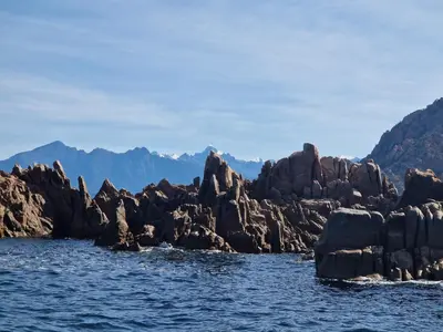 a group of rocks in the water with mountains in the background at T2 vue mer & montagne Golfe de Porto-Ota in Porto Ota