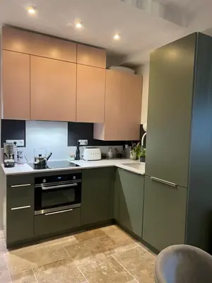 a kitchen with green cabinets and white counter tops at A Casa Laetizia in Eccica-Suarella