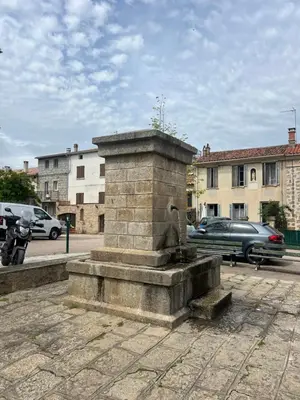 a stone fountain in the middle of a street at A Casa Laetizia in Eccica-Suarella