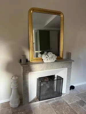 a mirror sitting on top of a fireplace at A Casa Laetizia in Eccica-Suarella