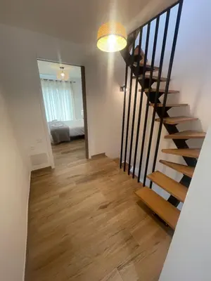 a stairway leading to a room with a bed at Petite maison de village in Bastelica