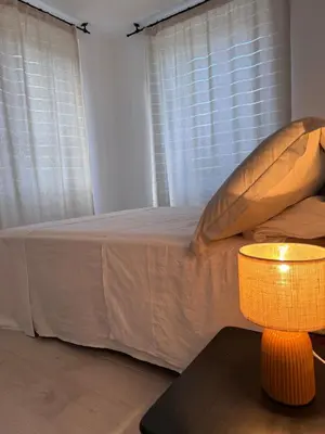 a bedroom with a bed and a table with a lamp at Appartement au cœur du village in Murato