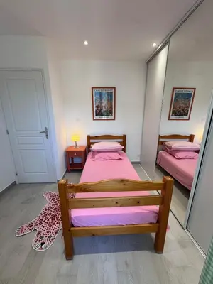a bedroom with two beds with pink sheets at Appartement au cœur du village in Murato