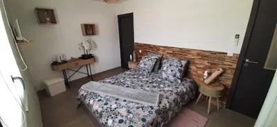 a bedroom with a bed and a brick wall at Chez bigoudy in Penta-di-Casinca