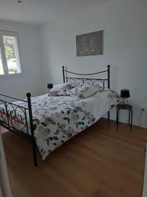 a bedroom with a bed with a floral comforter at Grand F2 vue montagne in Olmeta-di-Tuda