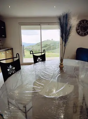 a dining room with a glass table and a window at Grand F2 vue montagne in Olmeta-di-Tuda