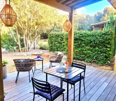 a patio with tables and chairs on a wooden deck at Studio à Bonifacio in Bonifacio