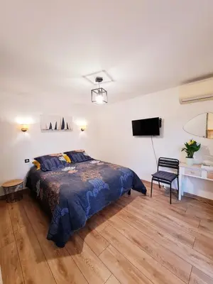 a bedroom with a bed and a tv on the wall at Studio à Bonifacio in Bonifacio