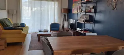 a living room with a wooden table and a couch at Charmant cosy T3 in Ajaccio