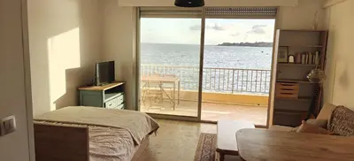 a bedroom with a balcony with a view of the ocean at Appartement pieds dans l eau in Ajaccio