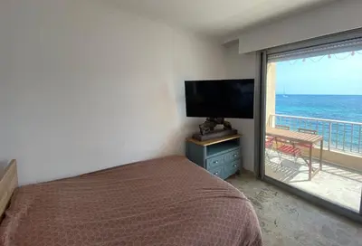 a bedroom with a bed and a view of the ocean at Appartement pieds dans l eau in Ajaccio