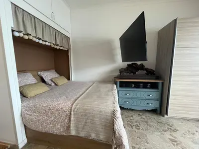 a bedroom with a bed and a flat screen tv at Appartement pieds dans l eau in Ajaccio