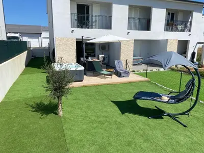 a lawn with a chair and an umbrella in a yard at Casa linsia in Aléria